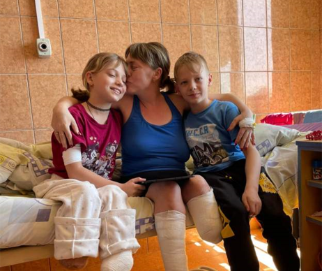 O femeie din Ucraina și fiica sa, rămase invalide după bombardamentele rusești de la gara Kramatorsk. Fratele geamăn al fetiței are grijă de cele două thumbnail