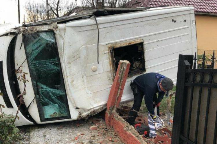 Accident la Cluj! Mașina de transport valori răsturnată în curtea unei case - VIDEO