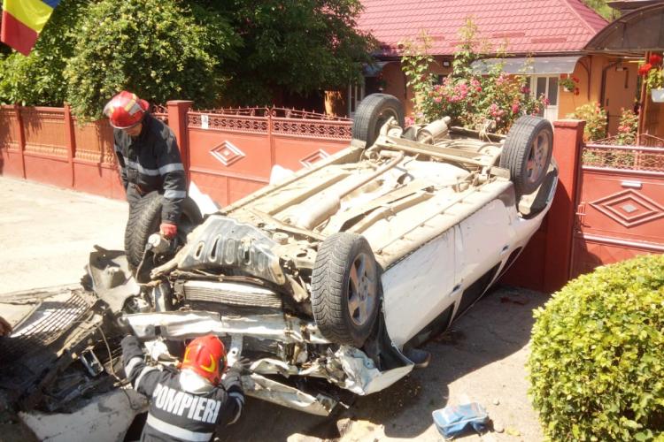 Accident pe drumul Cluj-Gherla. Un șofer s-a răsturnat cu mașina în fața unei porți FOTO