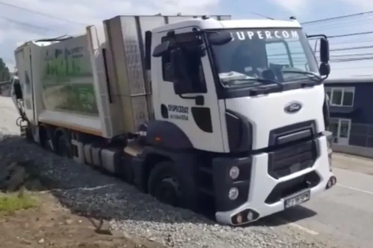 Ca-n filmele cu proști! Mașină de gunoi înghițită de șosea la Dej - VIDEO