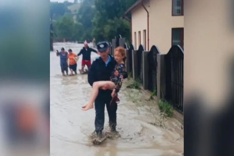 Rebeca, fetița de 10 ani cărată pe brațe de un jandarm, după ce casa i-a fost luată de ape, în județul Alba - FOTO