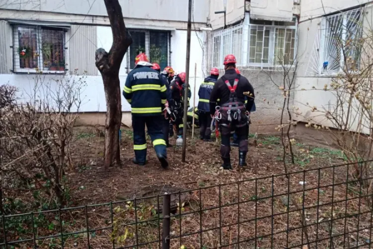 O femeie a rămas blocată în gura de aerisire a unui bloc, unde a intrat ca să salveze o pisică. Pompierii încearcă să o scoată cu ulei - VIDEO