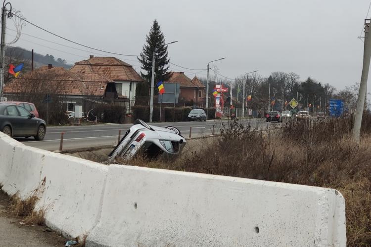Graba strică treaba! Asta a învățat un șofer din Cluj după ce a ajuns cu roțile în sus, pe marginea străzii - FOTO