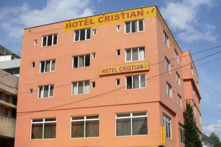 Cade tencuiala de pe hotelul Cristian, din Piața Mihai Viteazu, construit ilegal pe trotuar - FOTO