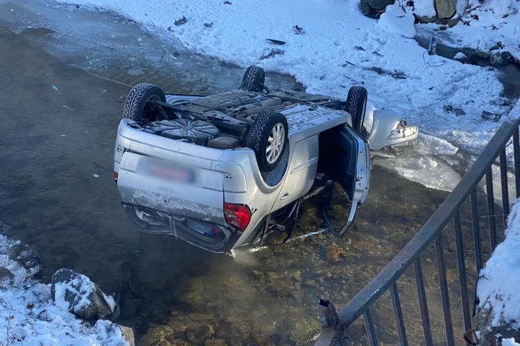 O masina a plonjat într-un râu înghețat din județul Cluj. Mașina a căzut 5 metri și s-a răsturnat - FOTO