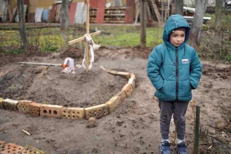 Fotografie dramatică din orașul ucrainean Bucea. Copil lângă mormântul mamei - FOTO