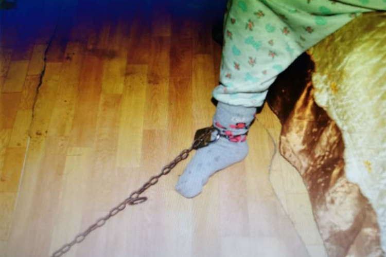 Cruzime fără margini! O femeie acuzată că și-a legat nepoata cu un lanț de piciorul patului, arestată la domiciliu