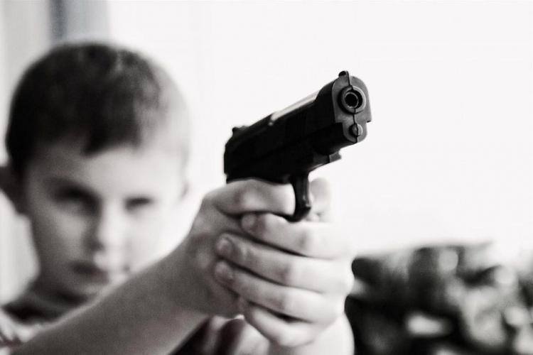 Un băiețel de 6 ani și-a împușcat sora mai mică, cu un pistol găsit în camera părinților. Cei doi adulți, acuzaţi de neglijenţă