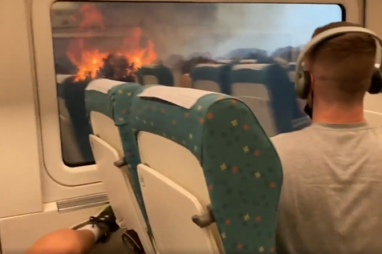 VIDEO - Imagini cu momentul în care pasagerii unui tren oprit în mijlocul câmpului realizează că sunt înconjurați de flăcări