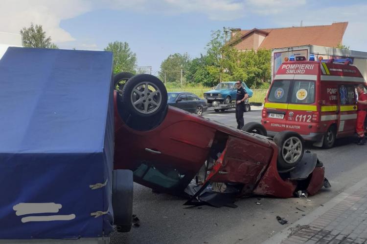 Cum a reușit așa ceva? O mașină care tracta o autoremorcă s-a răsturnat în Dej - FOTO