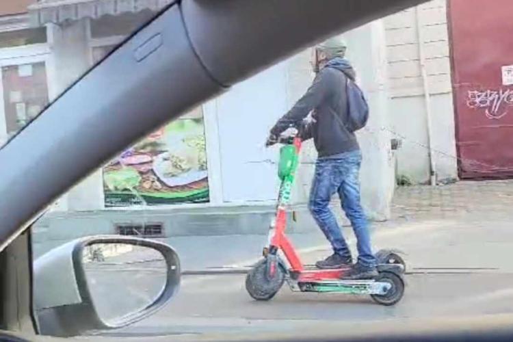 Clujenii duc transportul alternativ la un nou nivel. Bărbat filmat în timp ce merge cu două trotinete pe o stradă din centrul orașului - VIDEO