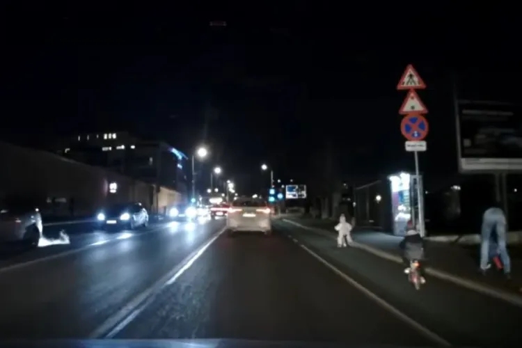 Părinți inconștienți la Cluj! Doi copii foarte mici filmați pe o pistă de biciclete, neseparată de carosabil, pe întuneric, fără lumini! VIDEO