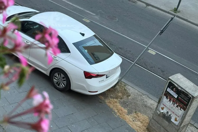 Parcare „à la Cluj”: O mașină urcată pe trotuar a lovit în plin un indicator rutier, pe care l-a îndoit dramatic. Semnul a cedat, șoferul nu