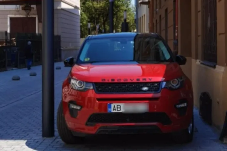 Nesimțire cu numere de Alba în centrul Clujului! Land Rover roșu parcat pe trotuar, lipit de clădire și stâlp: „Albanez venit la oraș”