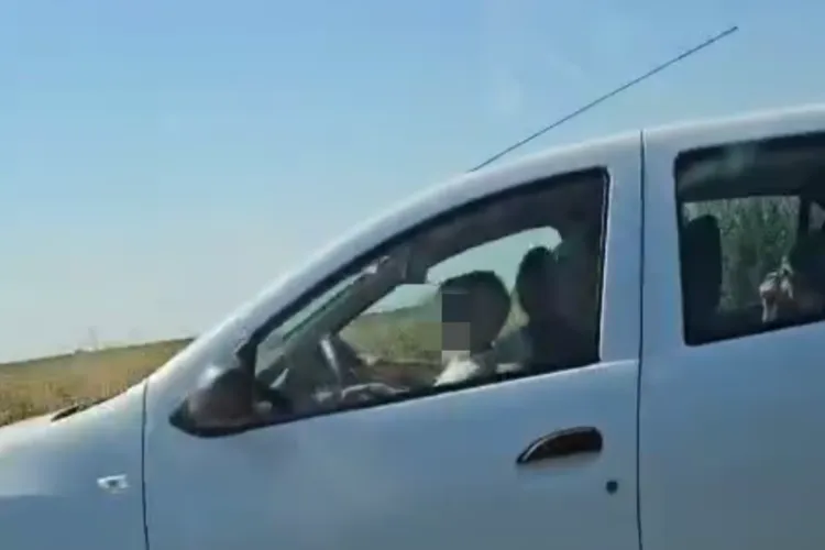 VIDEO. Copil filmat în trafic, la volan în brațele tatălui, în timp ce „conduce”. Pe locul din dreapta este încă un copil: „Cât de inconștient să fii!”