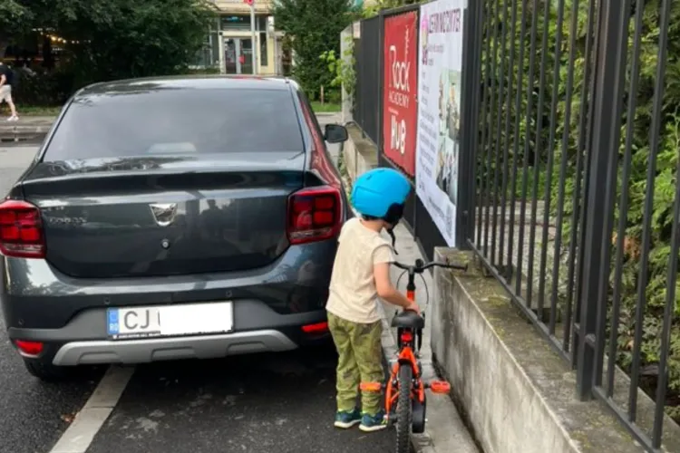 Un șofer din Cluj și-a parcat mașina pe trotuar, blocând complet accesul pietonilor. Un copilaș cu bicicleta încearcă să treacă, dar... n-are pe unde