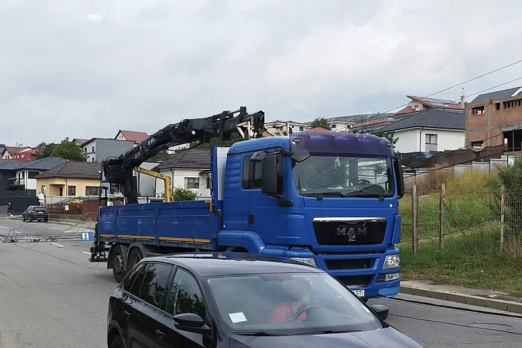 VIDEO Atenție șoferi clujeni! O stradă a fost blocată complet vineri: Doi stâlpi de curent doborâți de o macara, traficul spre Valea Chintăului oprit!