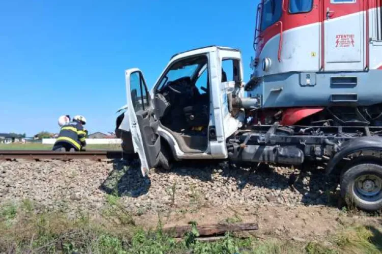 Impact violent între un tren și o autoutilitară! Șoferul a fost aruncat din vehicul. Pompierii au intervenit de urgență 