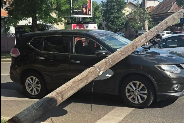 Clipe de groază pentru o familie cu doi copii de 9 și 11 ani: Un stâlp s-a prăbușit peste mașină în care erau toți patru și așteptau la semafor 