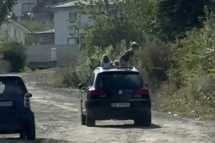 VIDEO. Inconștiență totală a unui părinte! Doi copii, lăsați să se distreze pe acoperișul unei mașini aflate în mers 
