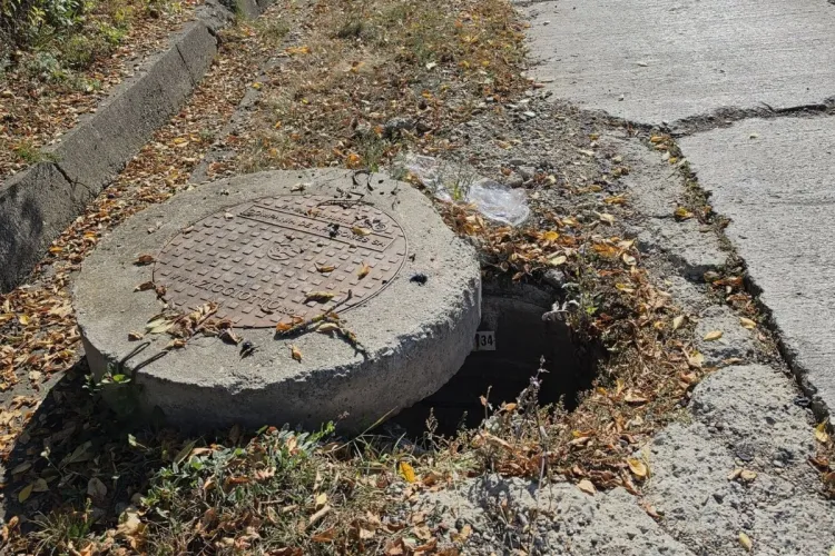 Pericol pe o stradă dintr-o comună din Cluj! Un capac masiv de canalizare s-a deplasat și a lăsat o parte din groapă complet descoperită