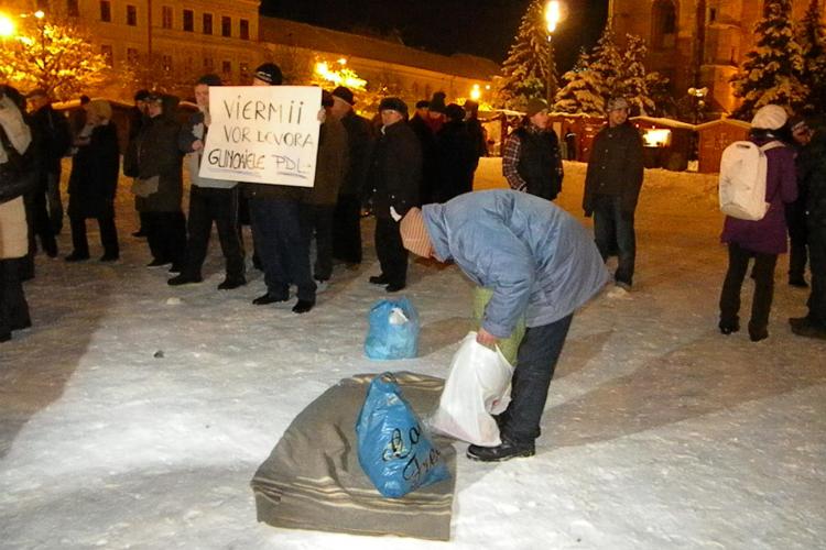 Protest excentric in Piata Unirii impotriva lui Traian Basescu! Un tanar  si-a intins patura pe zapada si a vrut sa se culce FOTO