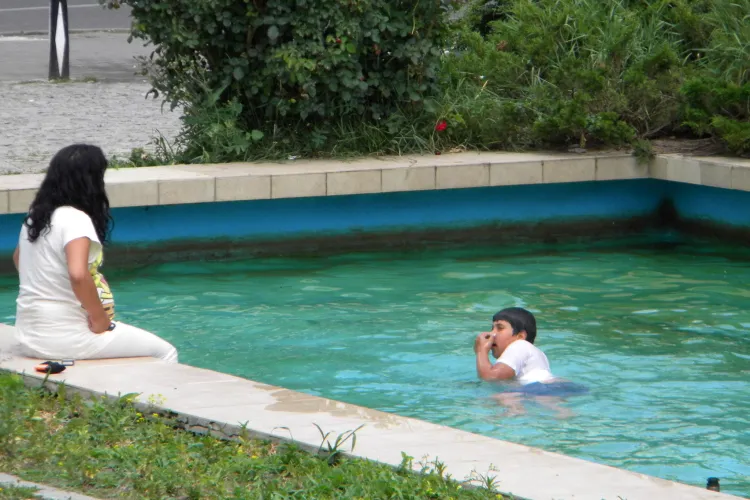 Căldura l-a împins să facă baie în fântâna arteziană din Piaţa Mihai Viteazu FOTO