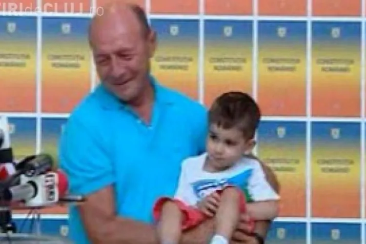 Băsescu a luat un copil în brațe la conferinţa de presă
