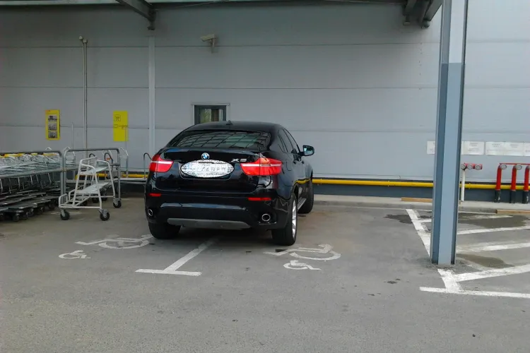 Șmecher cu BMW X6 parcat pe două locuri cu handicap la Baumax, pe Calea Turzii- FOTO
