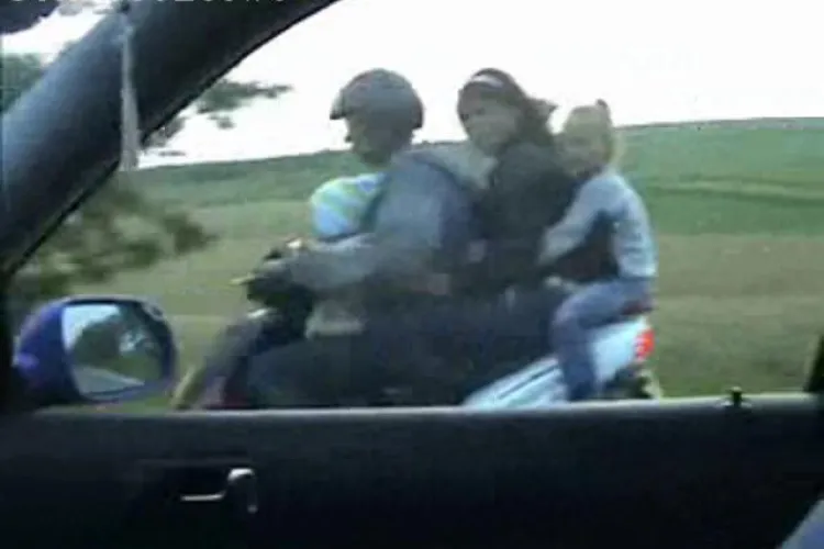 VIDEO - Patru pe un scuter pe un Drum National. Soferul inconstient are doi copii langa el si trece pe rosu