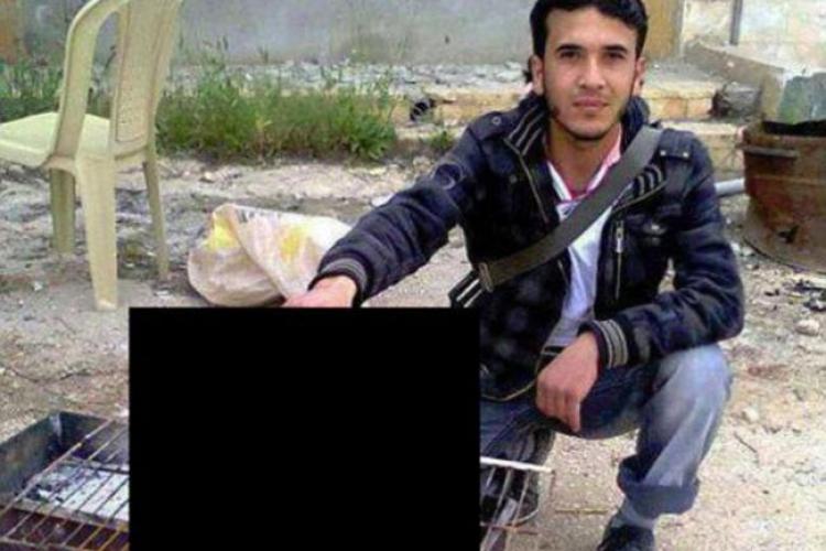 Un rebel sirian ţine capul decapitat al unui pilot pe grătarul încins - IMAGINI ȘOCANTE
