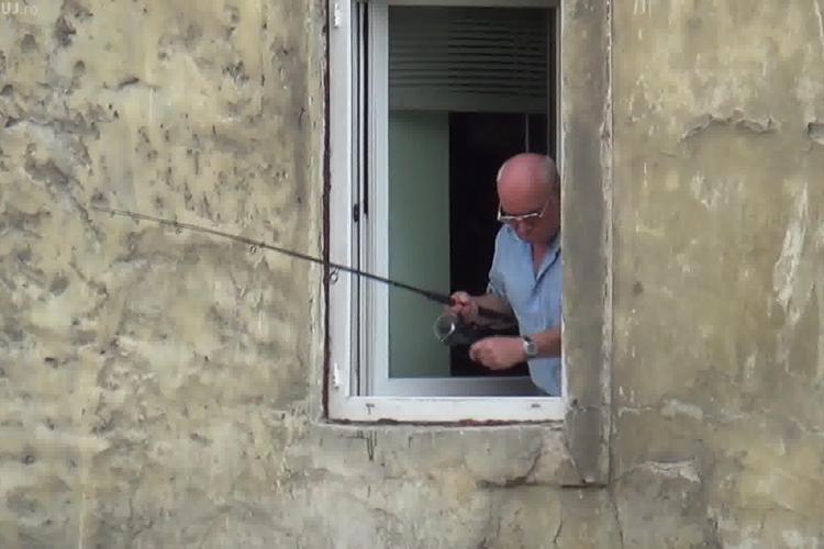 Scena asta are loc în Cluj-Napoca! Un bărbat pescuiește direct de la geamul casei - VIDEO