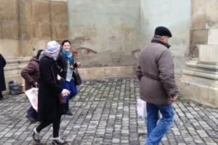 O clujeancă împarte bani nevoiașilor, în Piața Muzeului - FOTO